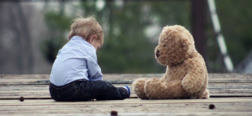 Child with toy on bridge.